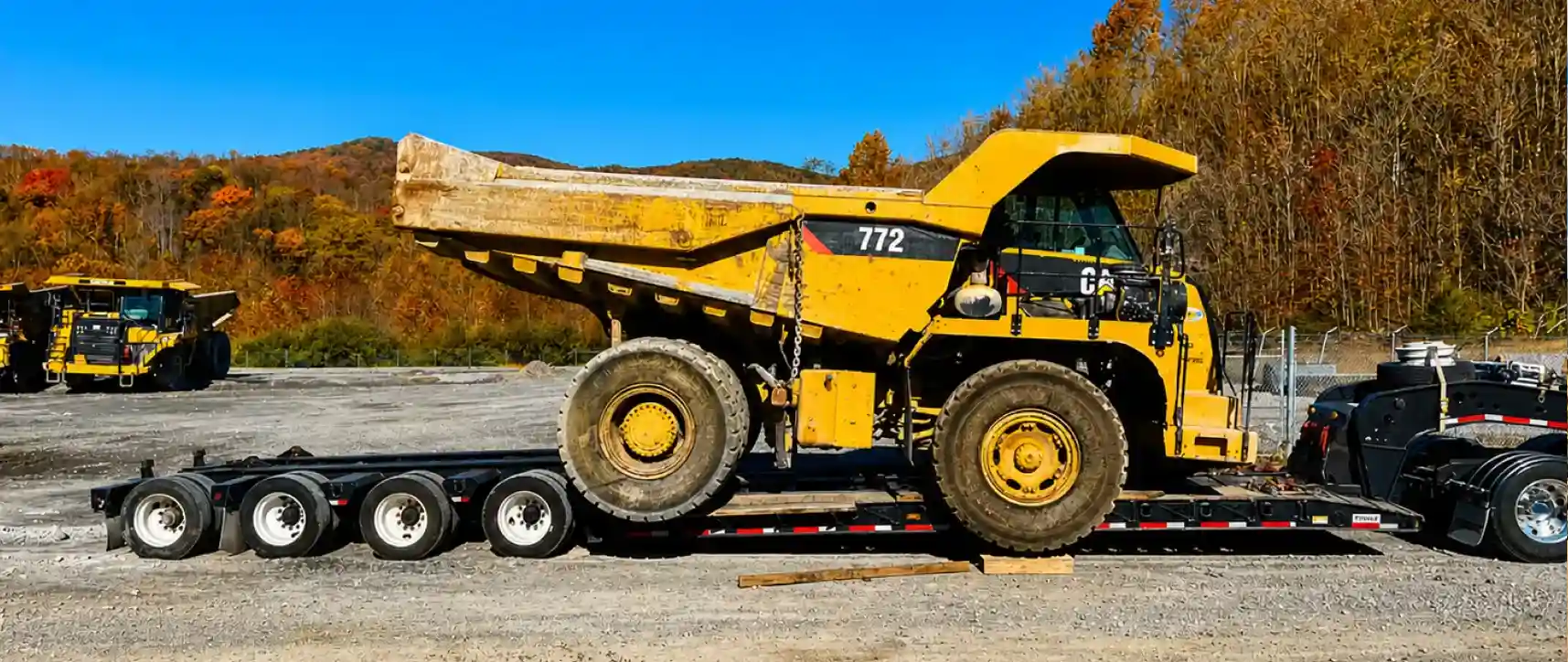 Camión volquete sobredimensionado cargado en un remolque lowboy para transporte de carga pesada en un sitio de construcción